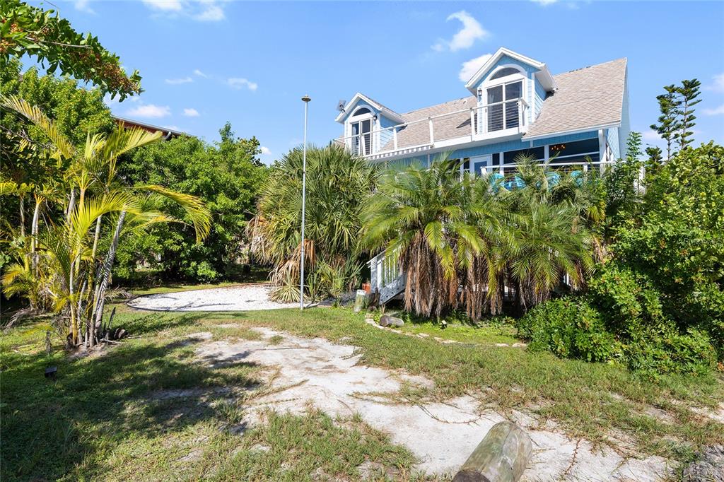 9368 Little Gasparilla Placida, FL 33946 - Photo 5 of 51 a front view of a house with a yard and trees