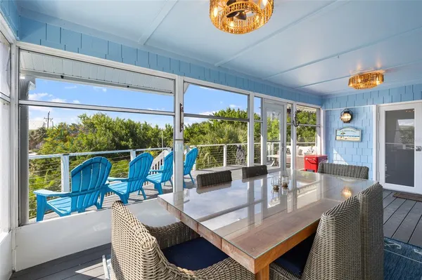 a view of a dining room with furniture large windows and wooden floor
