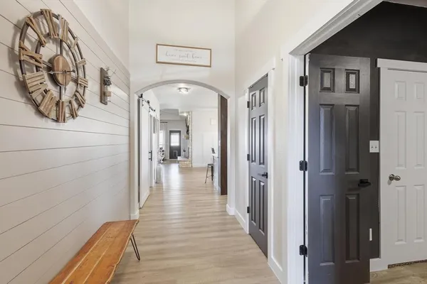 a view of a hallway with wooden floor and entryway