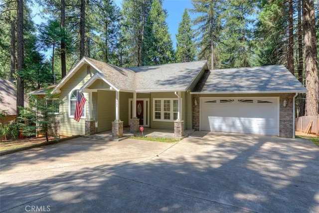 a front view of a house with a garden and trees