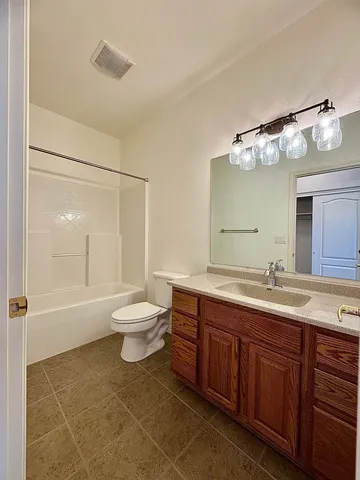 a bathroom with a toilet a sink and a large mirror
