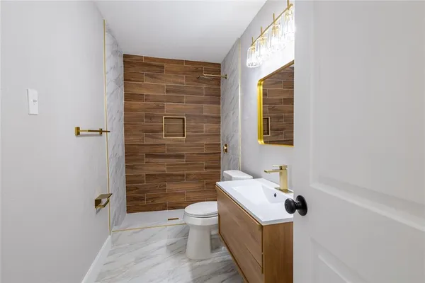a bathroom with a sink a toilet and shower