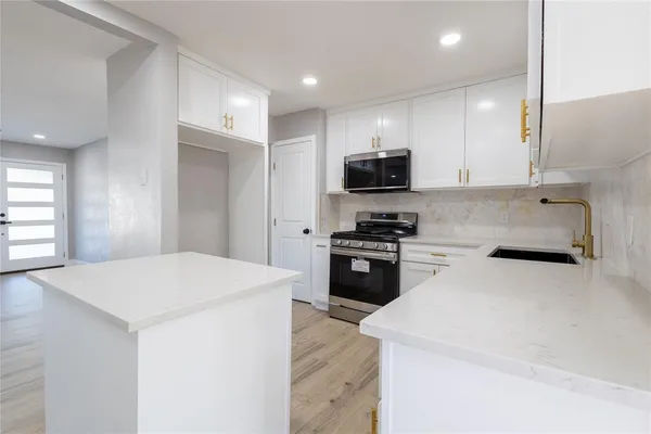 a kitchen with stainless steel appliances a microwave sink and refrigerator