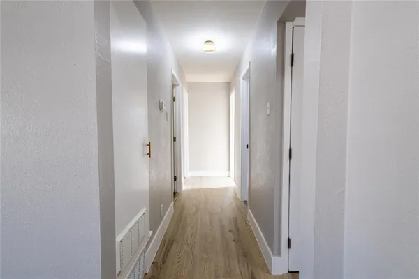 a view of a hallway with wooden floor