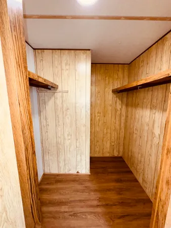 a view of a room with wooden walls and a window