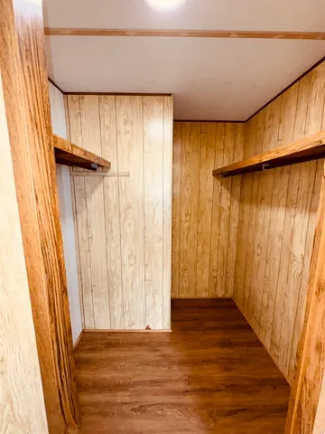 a view of a room with wooden walls and a window