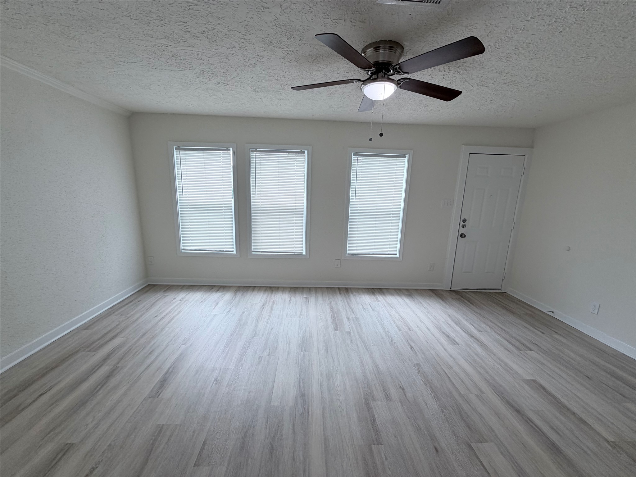 1112 3rd Street La Marque, TX 77568 - Photo 7 of 21 an empty room with wooden floor and windows