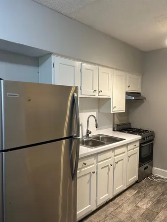 a kitchen with a sink a refrigerator and cabinets