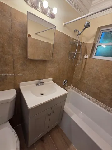 a bathroom with a sink mirror toilet and bathtub