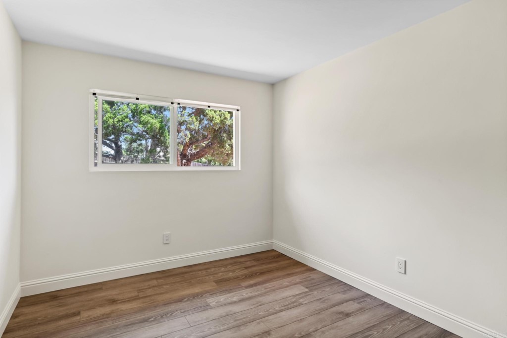 938 Doris Drive Encinitas, CA 92024 - Photo 18 of 31 an empty room with wooden floor and windows