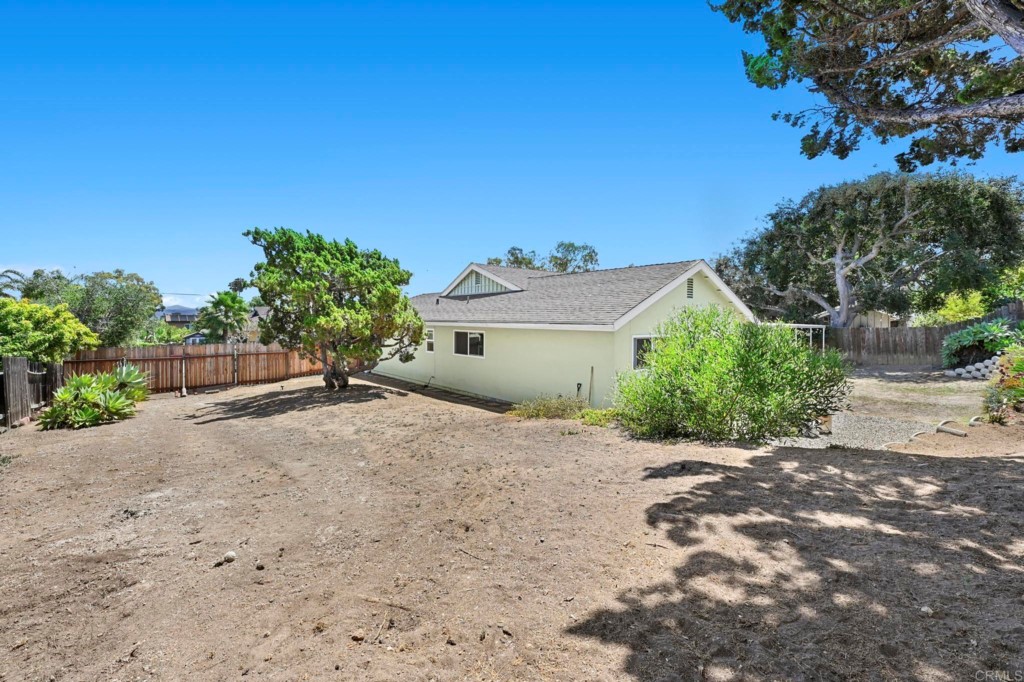 938 Doris Drive Encinitas, CA 92024 - Photo 26 of 31 a big house with a large tree and plants in front of it