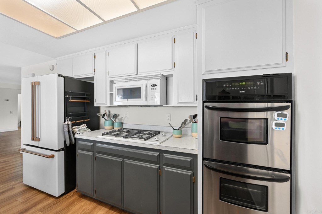 938 Doris Drive Encinitas, CA 92024 - Photo 10 of 31 a kitchen with cabinets stainless steel appliances and wooden floor