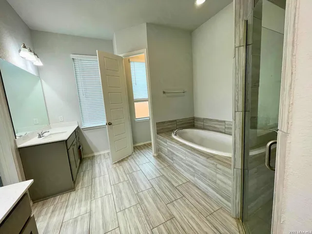 a bathroom with a granite countertop sink a toilet a mirror and bathtub