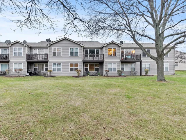 a view of a house with a big yard and large trees