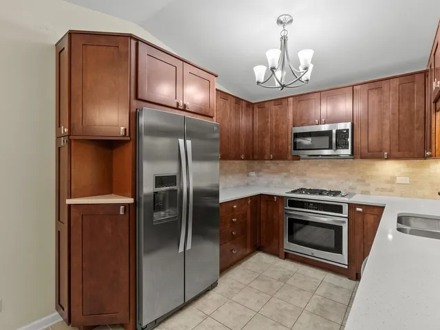 a kitchen with granite countertop stainless steel appliances and a refrigerator