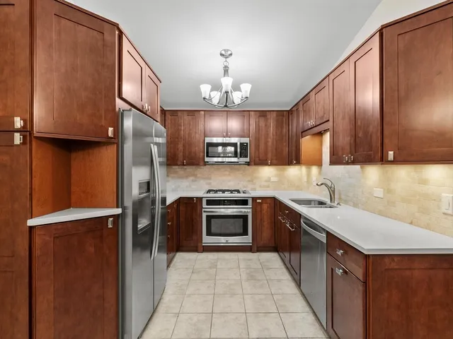 a kitchen with stainless steel appliances granite countertop a refrigerator stove and sink