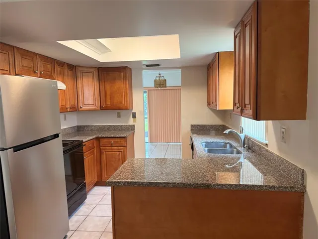 a kitchen with granite countertop a refrigerator and a sink