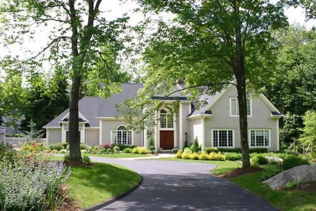 a front view of a house with a yard and trees