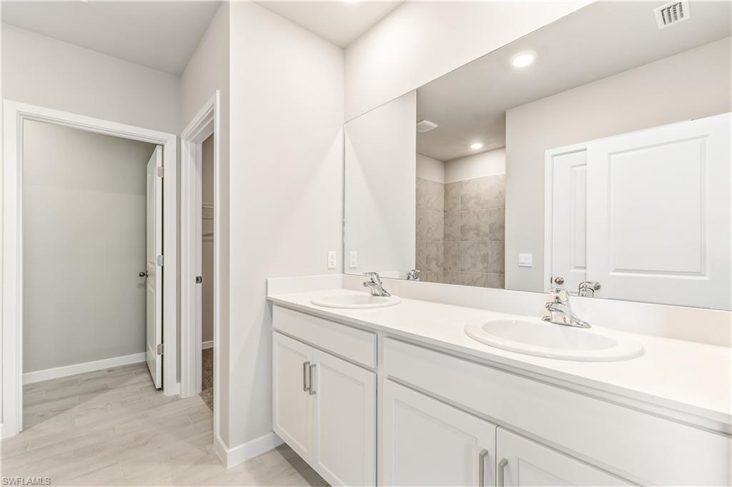 17770 Shade Tree Loop Punta Gorda, FL 33982 - Photo 15 of 47 a bathroom with a sink and a mirror