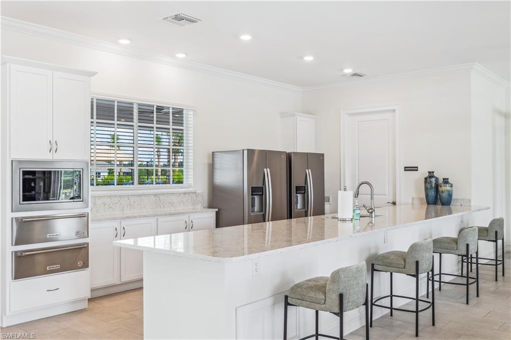 17770 Shade Tree Loop Punta Gorda, FL 33982 - Photo 27 of 47 a kitchen with stainless steel appliances kitchen island granite countertop a refrigerator and a stove top oven