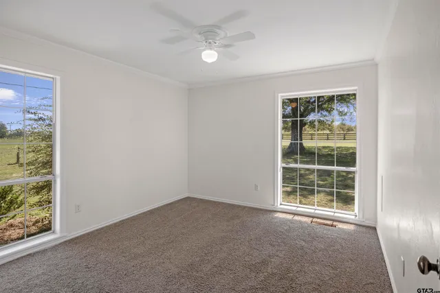 a view of a room with a ceiling fan and window