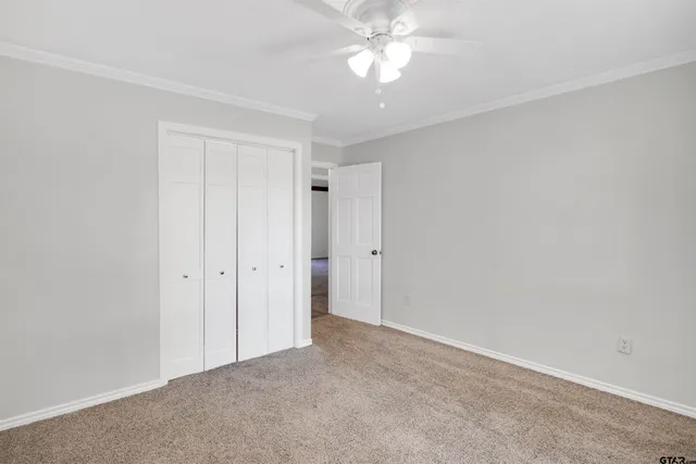 a view of an empty room with a ceiling fan