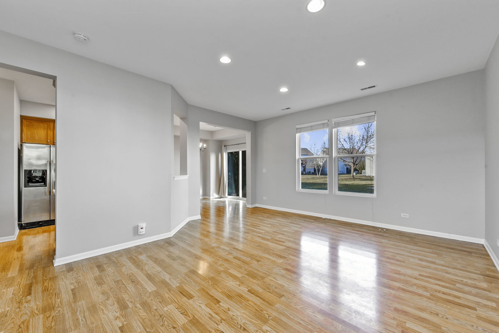3142 Bromley Lane Aurora, IL 60502 - Photo 2 of 15 a view of an empty room with wooden floor and a window