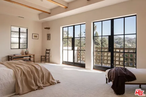 a bedroom with a bed and a large window