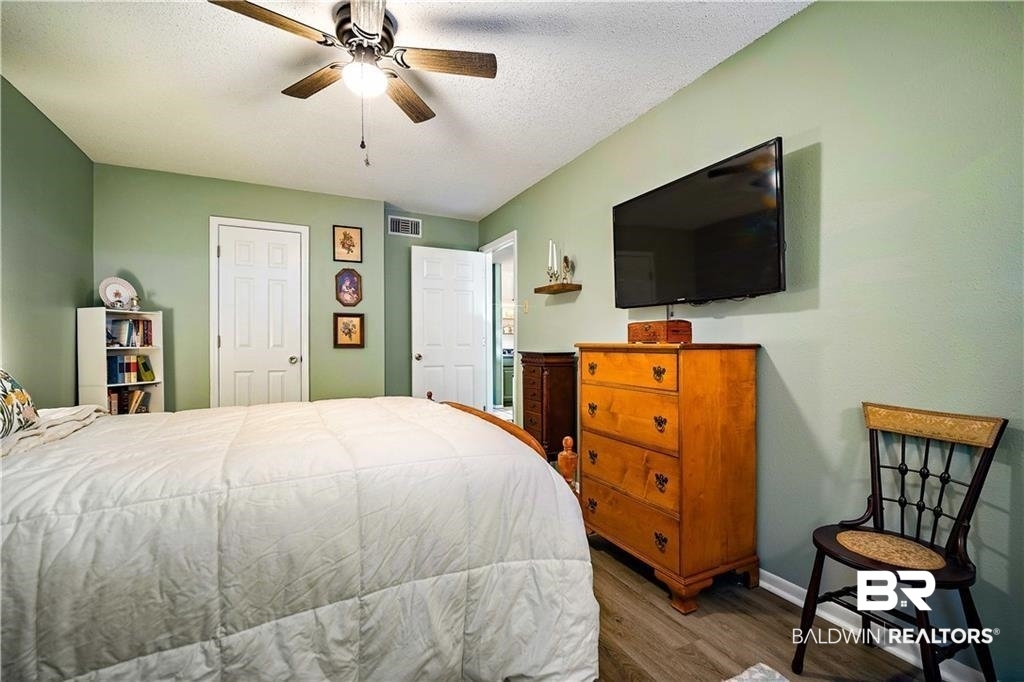 239 Riverbend Drive, Unit 239 Mobile, AL 36605 - Photo 23 of 26 Bedroom with ceiling fan, a textured ceiling, and wood-type flooring