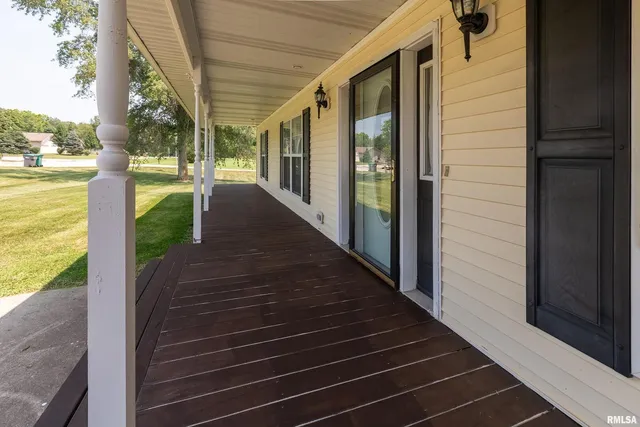 a living room with furniture two window and a wooden floor
