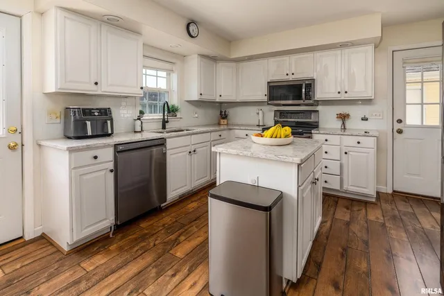 a kitchen with granite countertop a sink a stove and cabinets