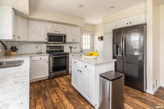 a kitchen with stainless steel appliances white cabinets and stove