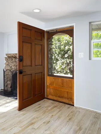 an empty room with wooden floor closet and windows