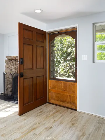 an empty room with wooden floor closet and windows