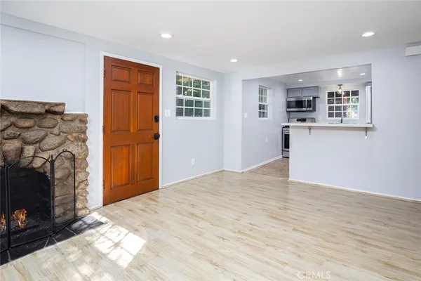 a view of a livingroom with wooden floor and a fireplace