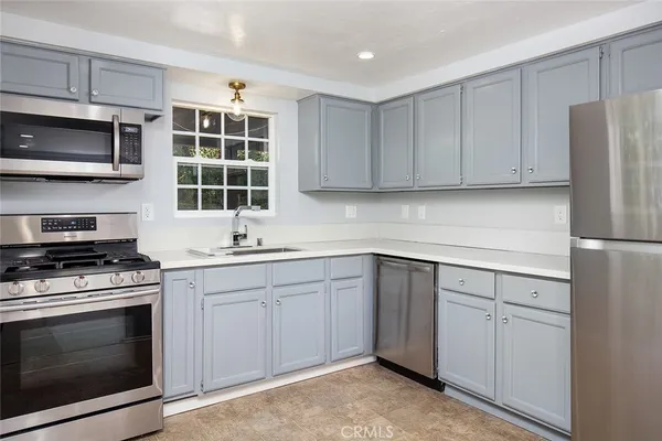 a kitchen with granite countertop cabinets stainless steel appliances and a sink