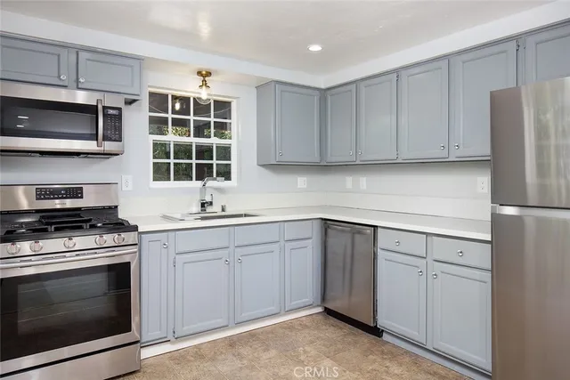 a kitchen with granite countertop cabinets stainless steel appliances and a sink