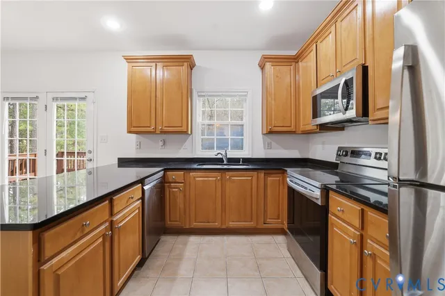 a kitchen with stainless steel appliances granite countertop a stove sink and cabinets