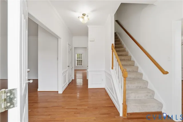 a view of a hallway with wooden floor and staircase
