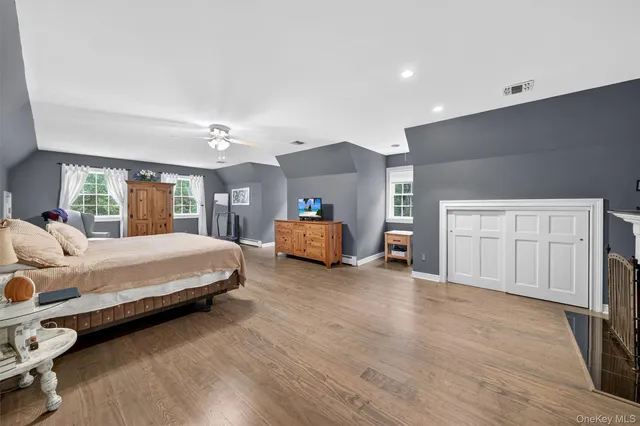 a spacious bedroom with a bed and dresser