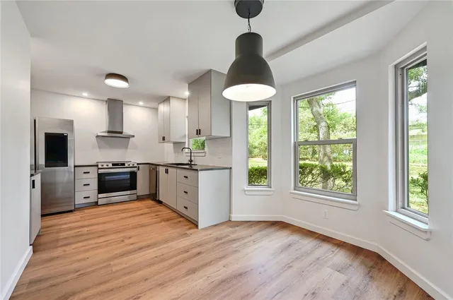 a kitchen with stainless steel appliances granite countertop a stove a sink and a refrigerator