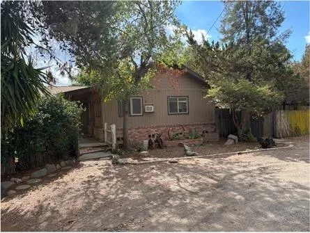 a house is sitting in middle of forest