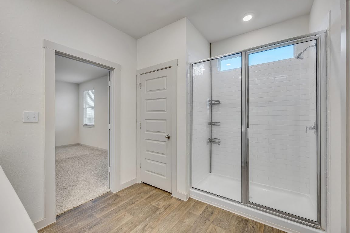 210 Big Cypress Bayou Road Hutto, TX 78634 - Photo 15 of 27 Full bath featuring a shower stall and light wood finished floors