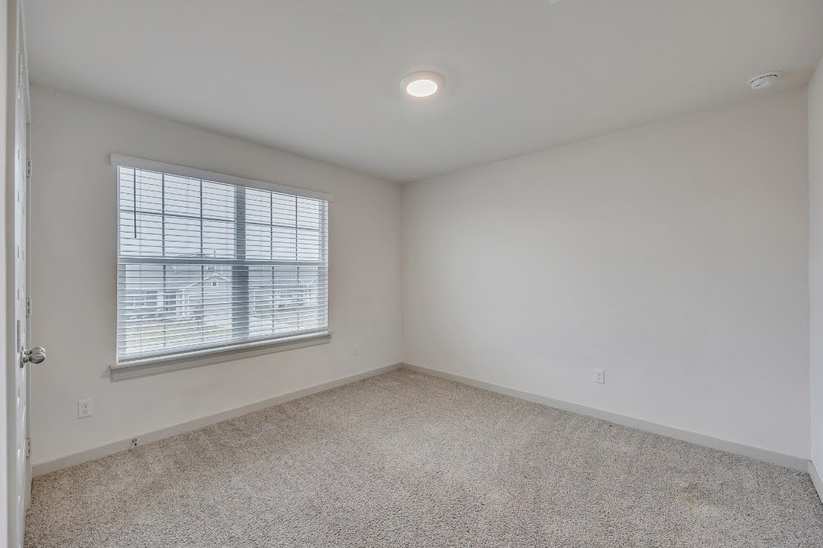 210 Big Cypress Bayou Road Hutto, TX 78634 - Photo 22 of 27 Spare room with light colored carpet and baseboards