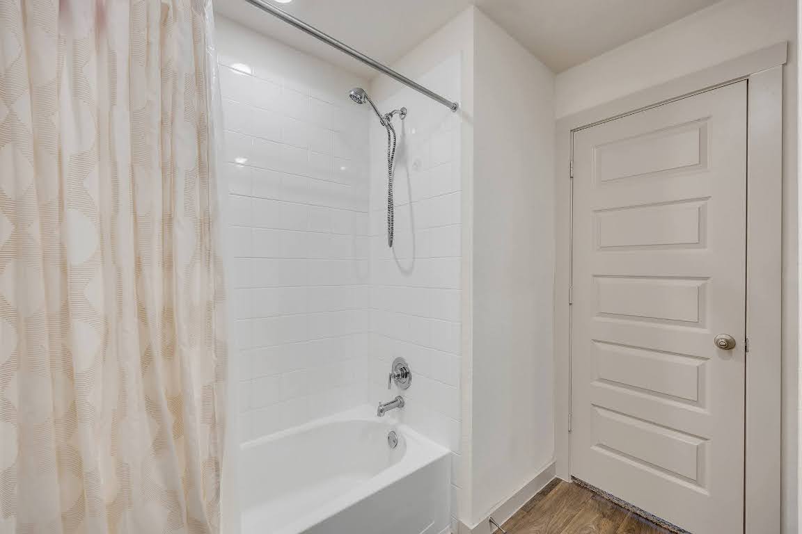210 Big Cypress Bayou Road Hutto, TX 78634 - Photo 24 of 27 Bathroom featuring shower / bath combo and wood finished floors