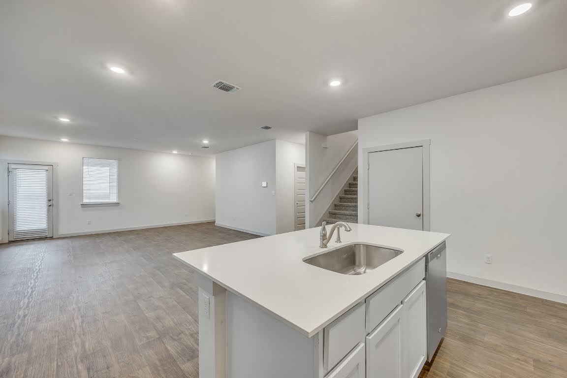 210 Big Cypress Bayou Road Hutto, TX 78634 - Photo 27 of 27 Kitchen featuring white cabinetry, an island with sink, recessed lighting, light wood-type flooring, and open floor plan