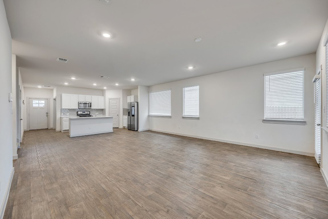 210 Big Cypress Bayou Road Hutto, TX 78634 - Photo 9 of 27 Unfurnished living room featuring light wood-type flooring, plenty of natural light, and recessed lighting