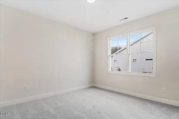 a view of an empty room and chandelier fan