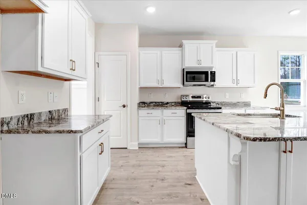a large white kitchen with white cabinets and a stove