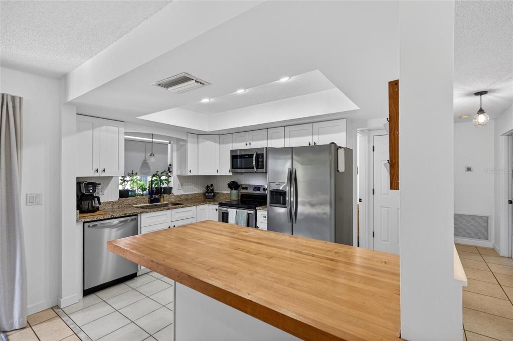 532 Center Road Venice, FL 34285 - Photo 40 of 68 a kitchen with stainless steel appliances kitchen island granite countertop a refrigerator and a sink